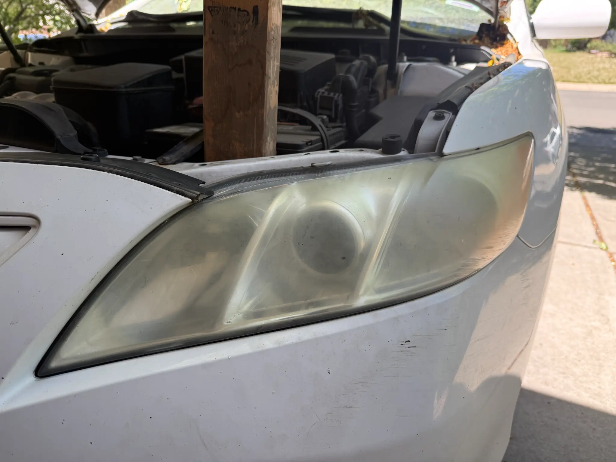 2009 Toyota Camry before headlight restoration — cloudy, yellowed headlights