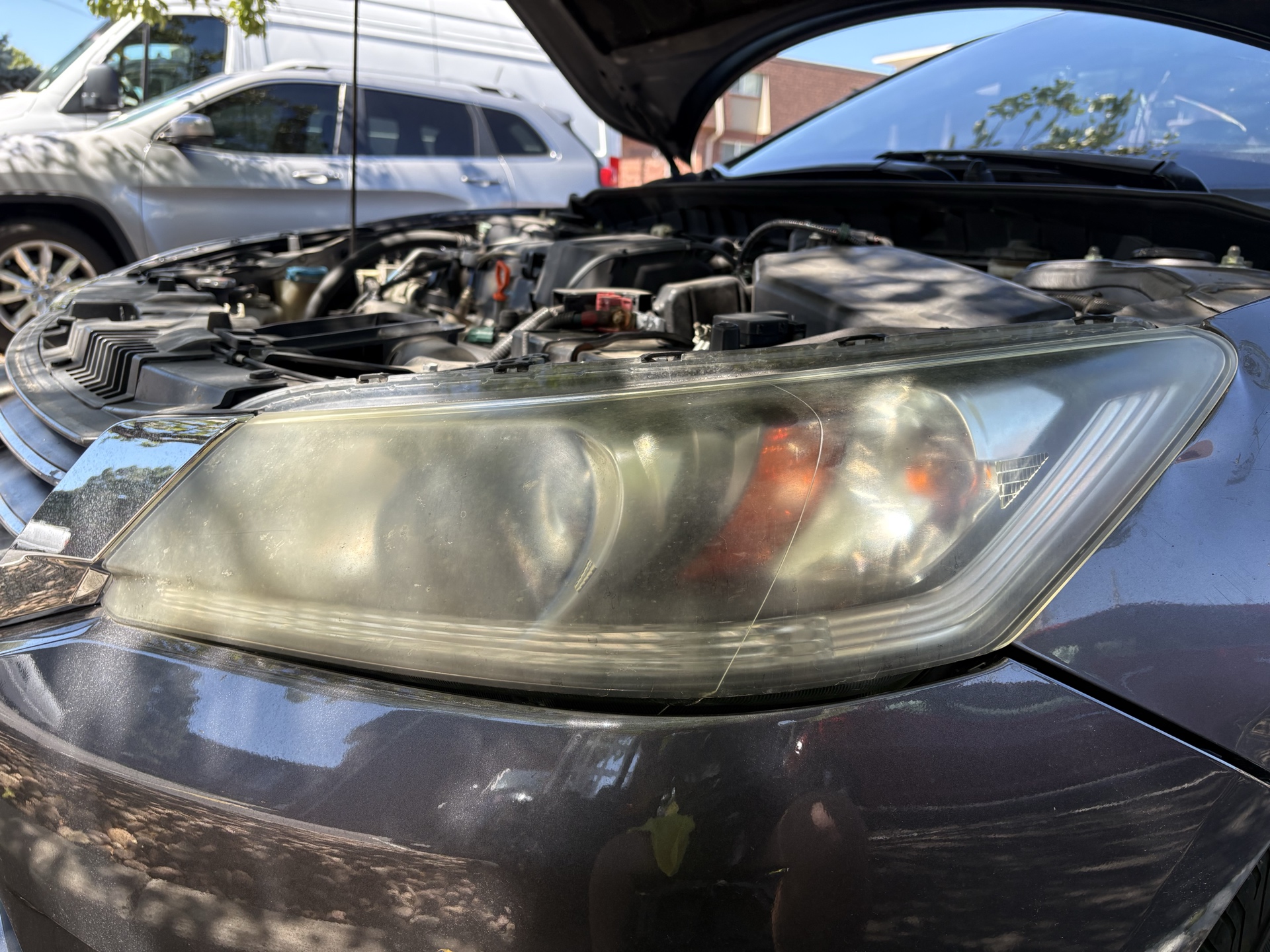 2015 Honda Accord headlight before restoration showing severe exterior oxidation and yellowing